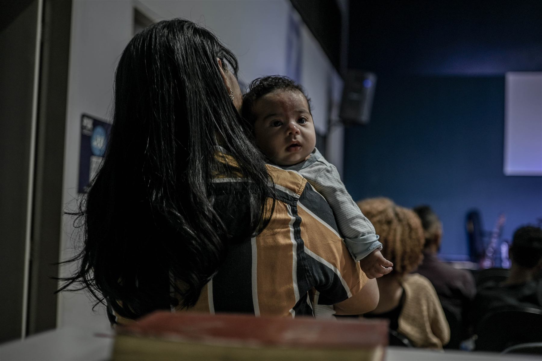 Mãe com criança durante o culto da Casa de Paz